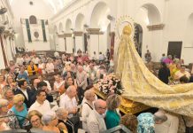 Los fieles pasan bajo el manto de la Virgen del Rosario en la festividad de la Patrona barreña